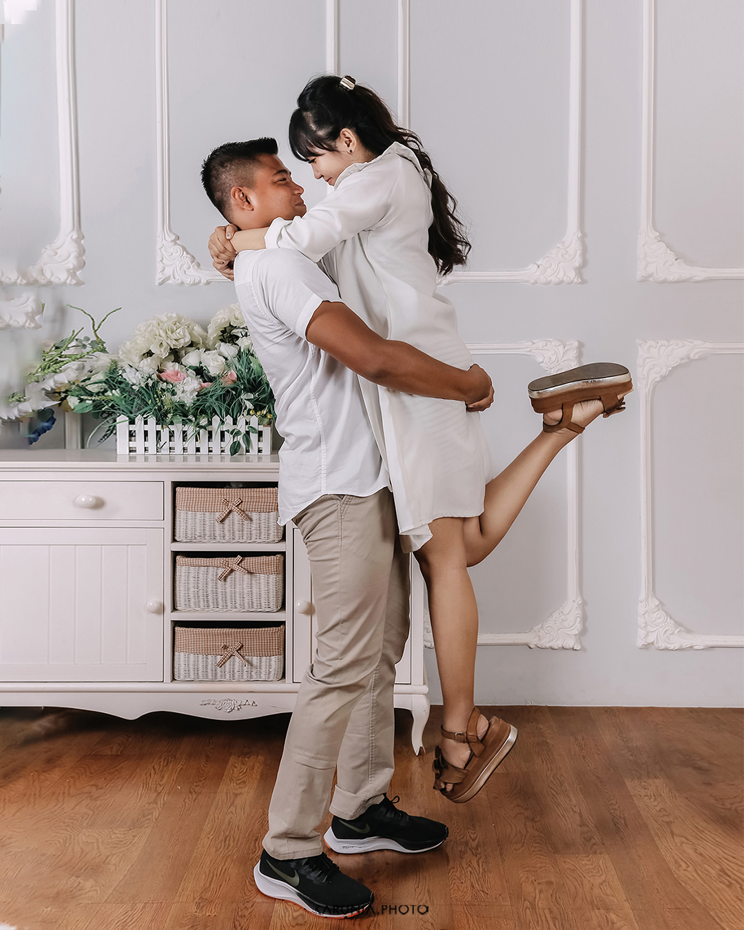 Bride and groom-to-be holding hands and walking along city streets with romantic bokeh lights